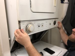 A technician fixing a washing machine.